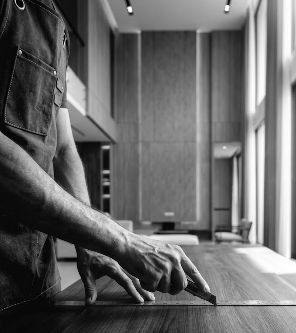 A tradie marking a measurement on a timber benchtop.